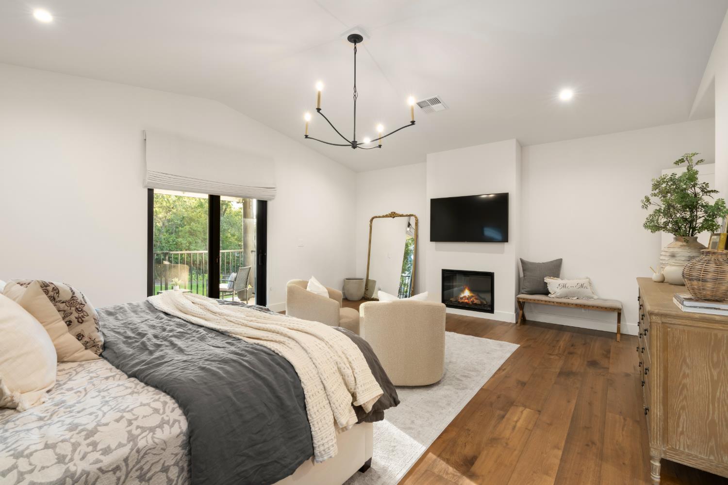 7697 Horseshoe Bar Road Loomis, CA 95650 - Photo 23 of 76 a spacious bedroom with a large bed and a fireplace