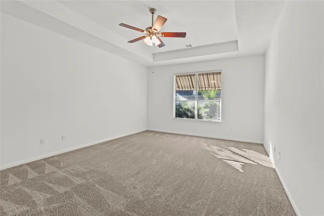 an empty room with windows and ceiling fan view