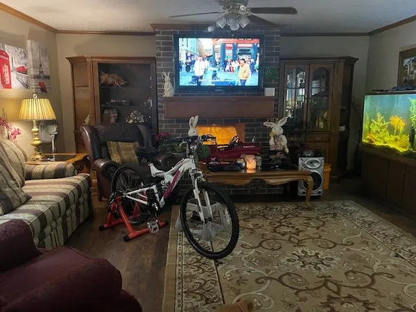 a living room with furniture a flat screen tv and floor to ceiling window