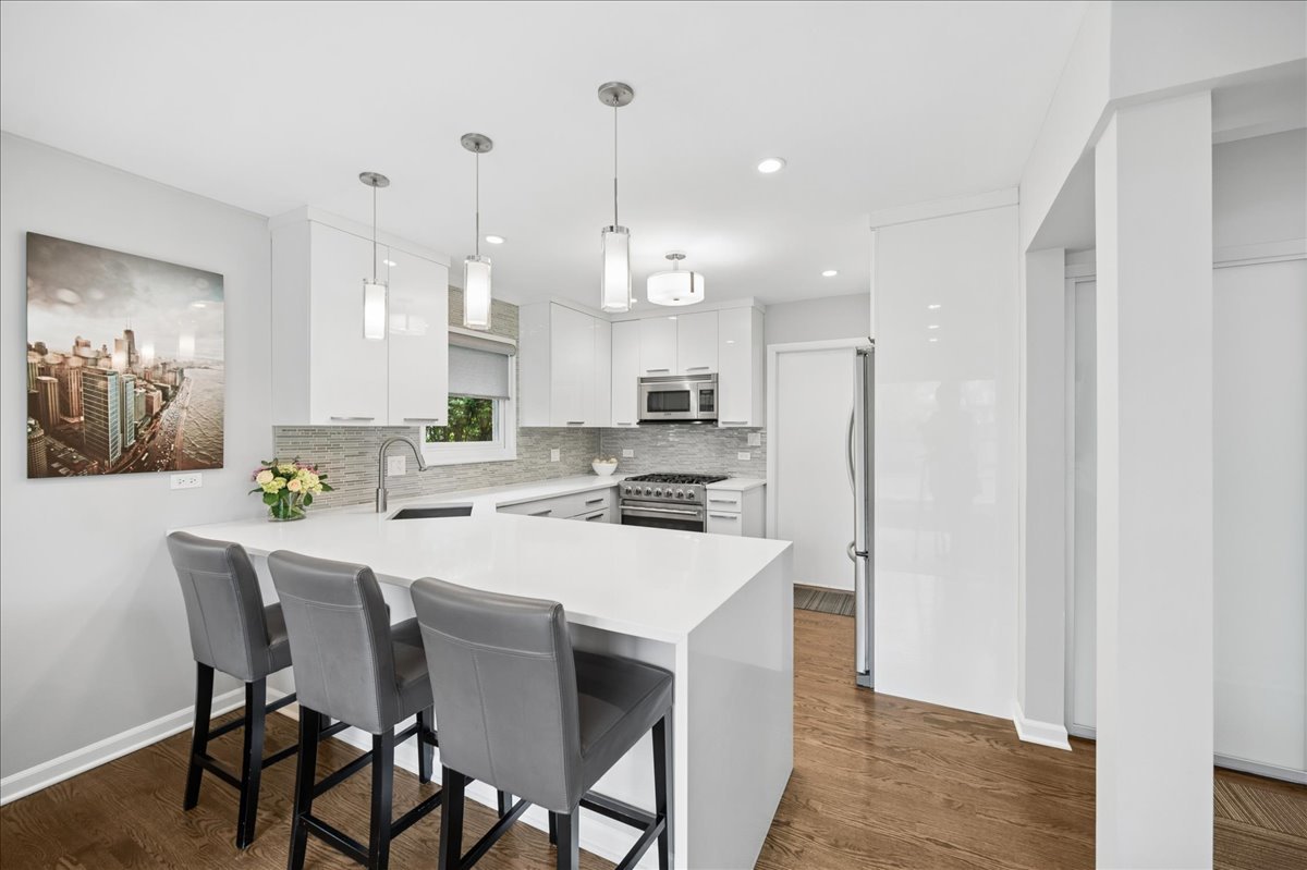 912 Hunter Road Wilmette, IL 60091 - Photo 14 of 38 a kitchen with kitchen island a stove a table and chairs