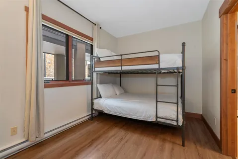 a bedroom with a bed and wooden floor