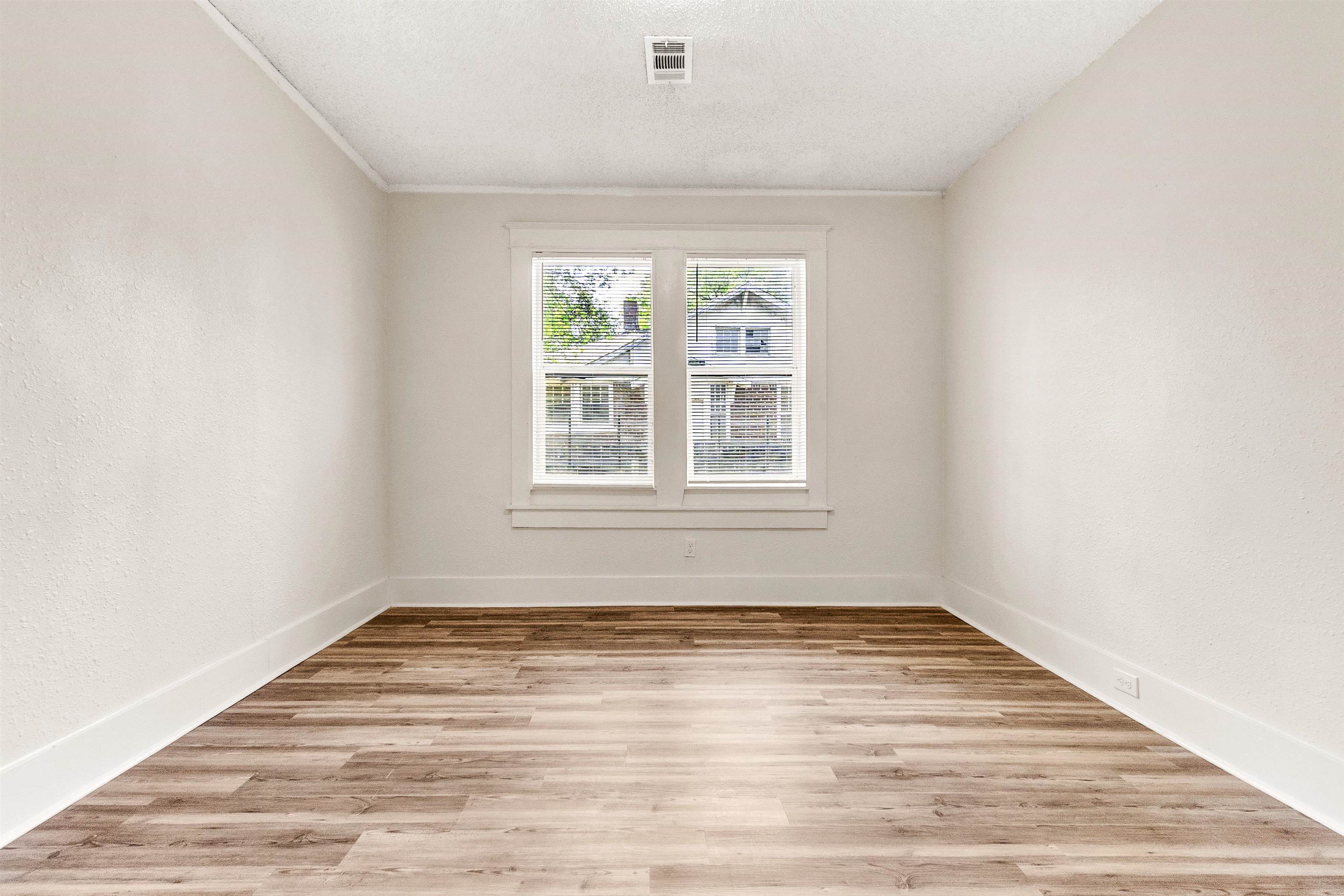 1100 Rozelle Street Memphis, TN 38106 - Photo 11 of 19 an empty room with wooden floor and windows
