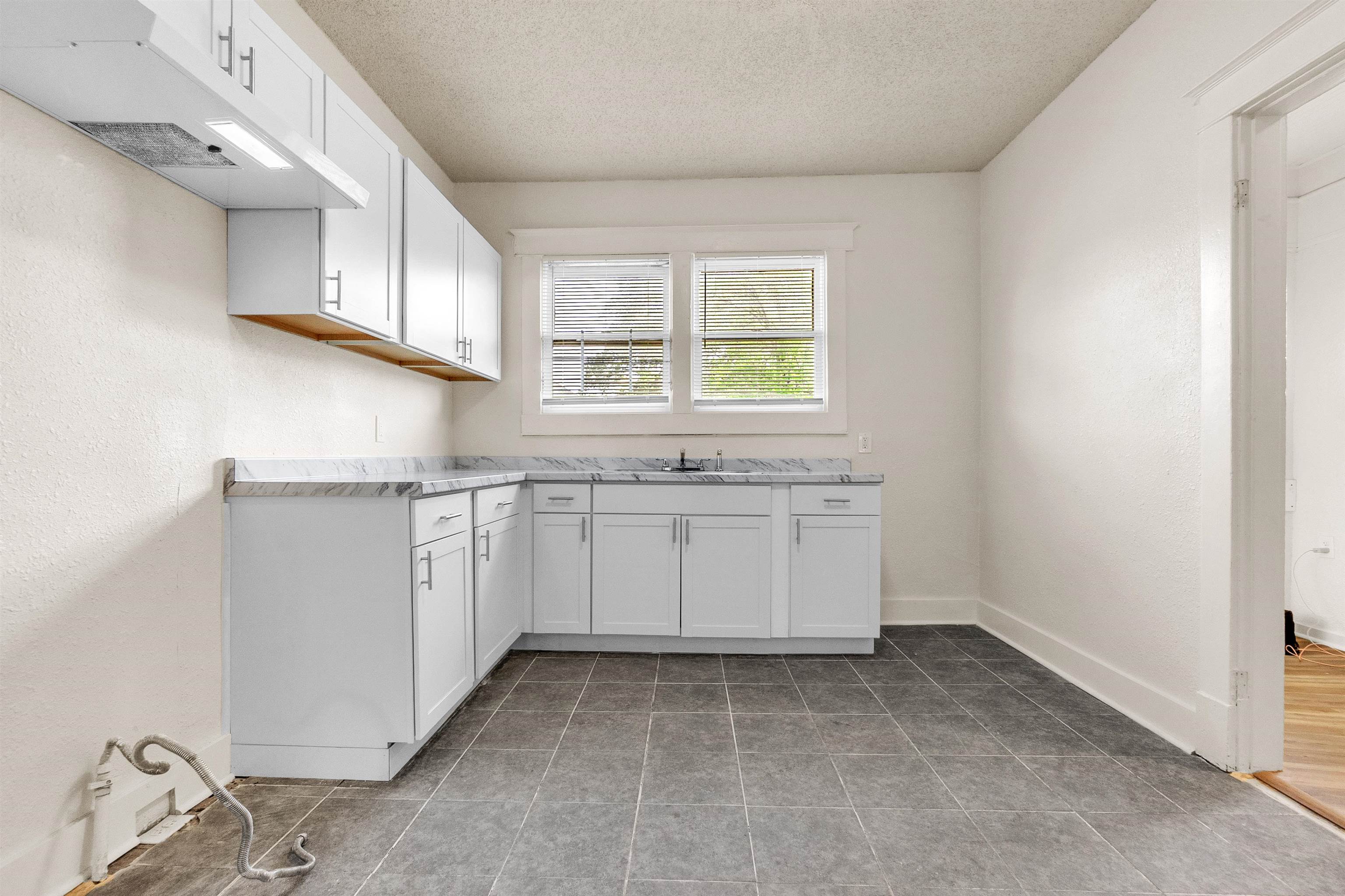 1100 Rozelle Street Memphis, TN 38106 - Photo 12 of 19 a kitchen with granite countertop white cabinets and white appliances