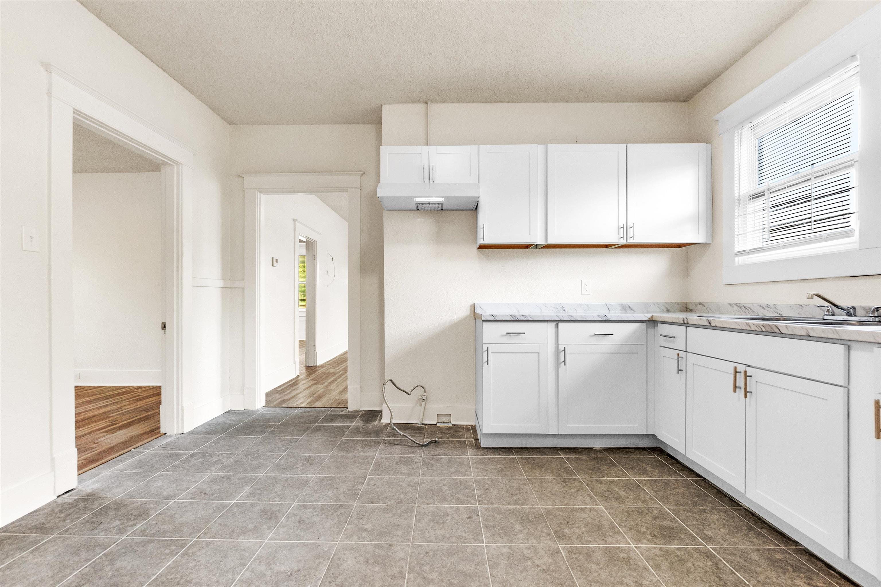 1100 Rozelle Street Memphis, TN 38106 - Photo 13 of 19 a kitchen with granite countertop white cabinets and white appliances