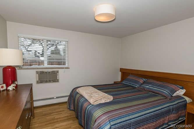 3520 Ward Road Wheat Ridge, CO 80033 - Photo 15 of 22 a bedroom with a bed and wooden floor