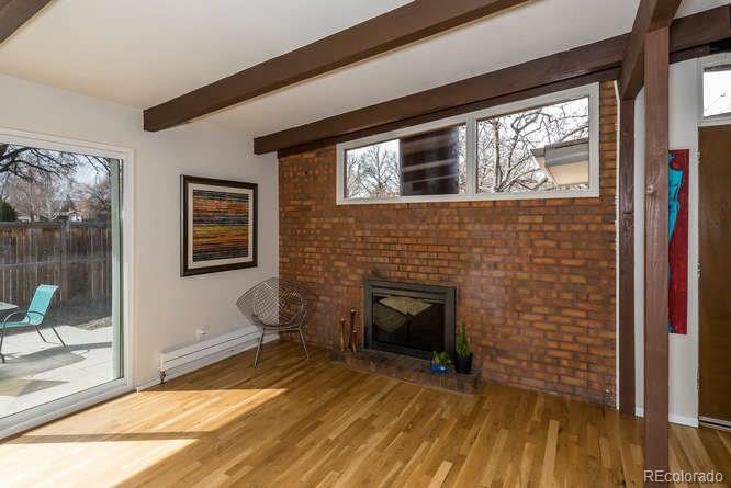3520 Ward Road Wheat Ridge, CO 80033 - Photo 3 of 22 a view of an empty room with wooden floor and a fireplace