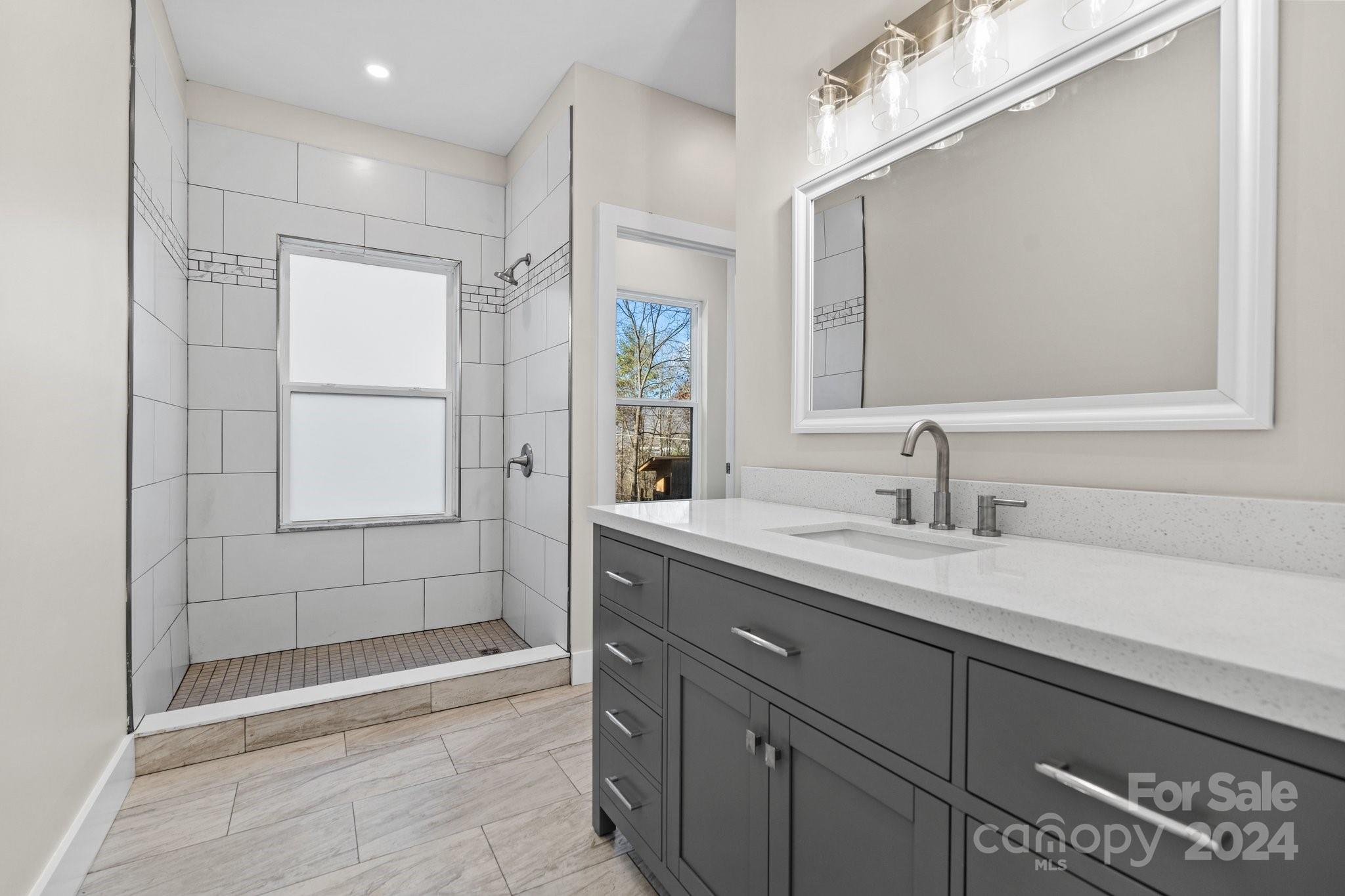 32 Access Road Black Mountain, NC 28711 - Photo 27 of 34 a bathroom with a shower sink and mirror