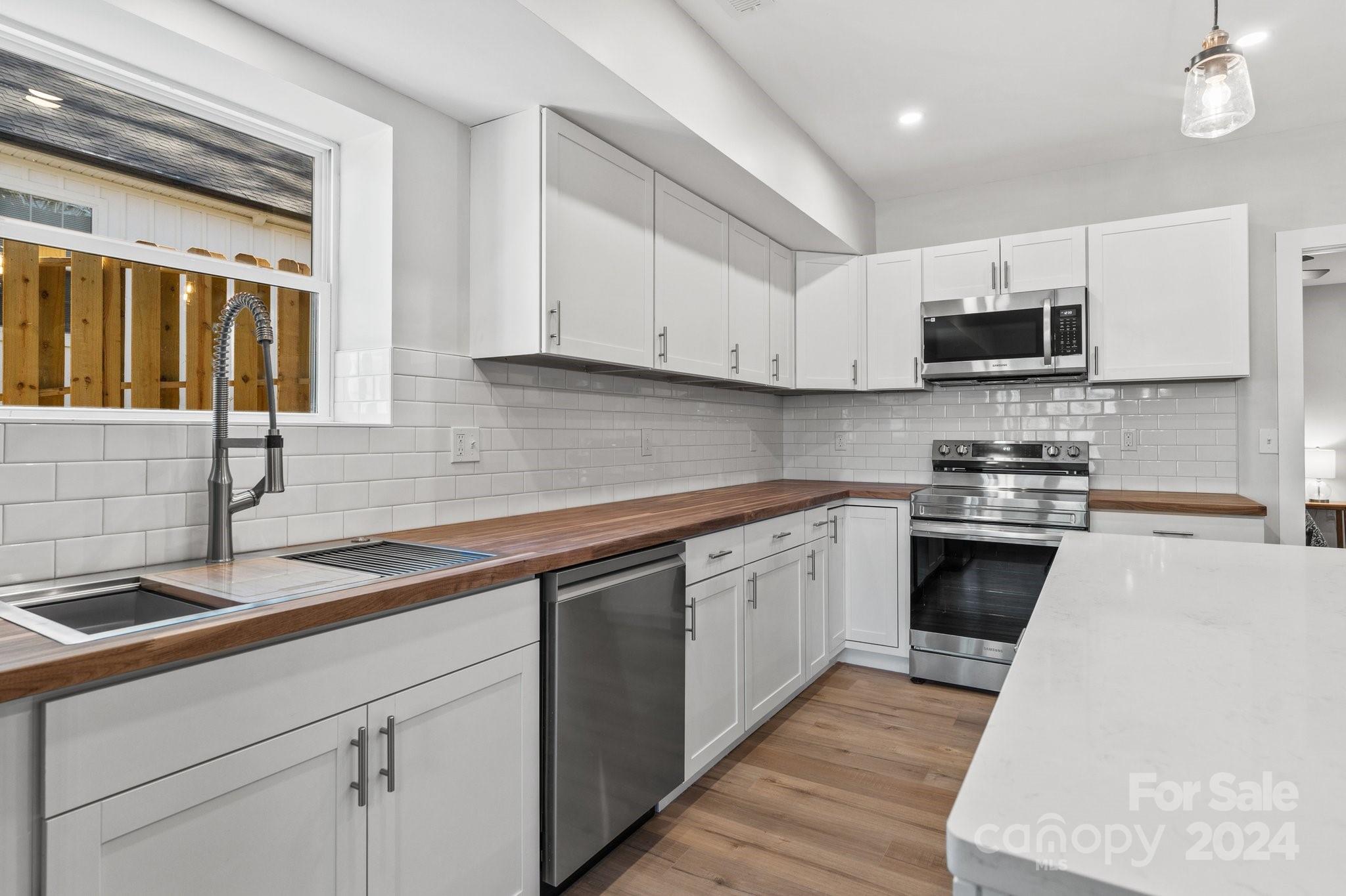 32 Access Road Black Mountain, NC 28711 - Photo 8 of 34 a kitchen with cabinets stainless steel appliances a sink and a stove