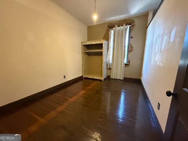 a view of a hallway with wooden floor and stairs
