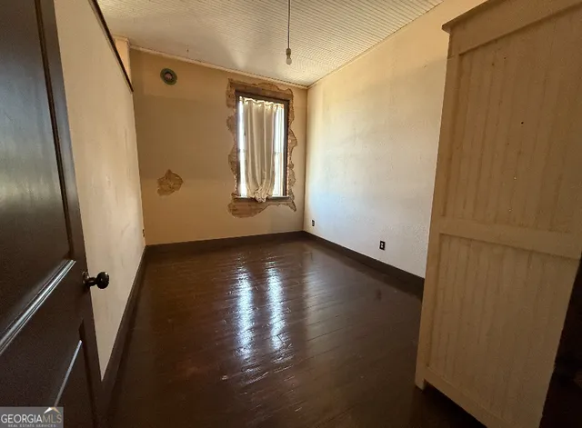 a view of a livingroom with wooden floor and a window
