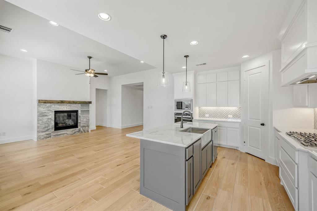 147 Derrett Lane Rhome, TX 76078 - Photo 7 of 28 a kitchen with a sink a counter top space stainless steel appliances and a fireplace