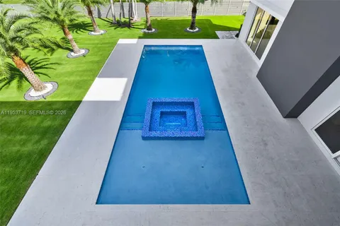 an aerial view of a house with swimming pool and garden