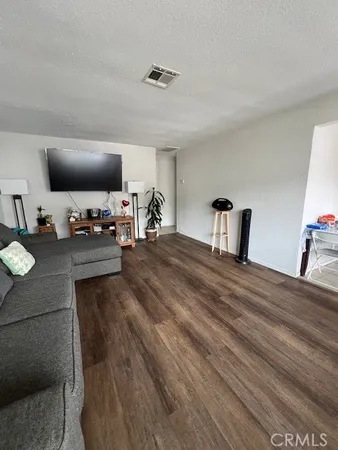 a bedroom with a bed and a flat tv screen on dresser