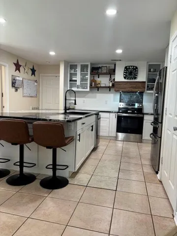 a kitchen with stainless steel appliances granite countertop a sink and a refrigerator