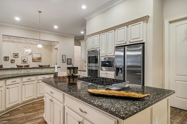 a kitchen with stainless steel appliances granite countertop a sink refrigerator and cabinets