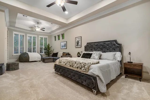 a spacious bedroom with a bed and ceiling fan