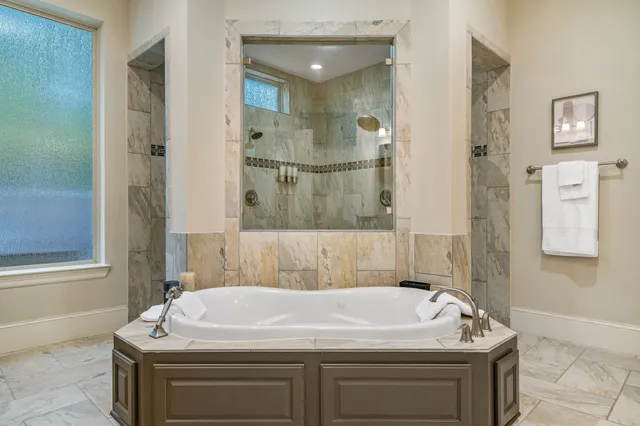 a bathroom with a tub sink and mirror