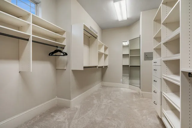 a view of walk in closet with empty racks