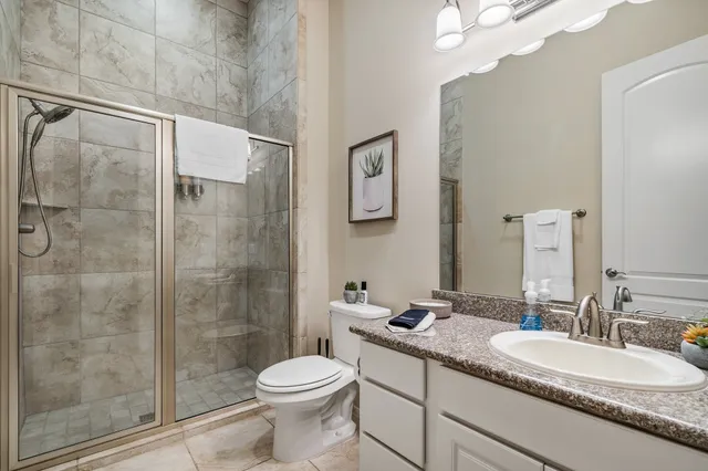 a bathroom with a granite countertop sink toilet and shower