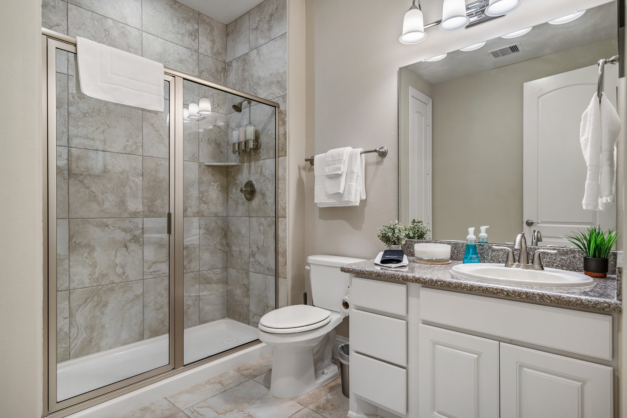27411 Hazy Landing Court Spring, TX 77386 - Photo 39 of 50 a bathroom with a granite countertop sink toilet a mirror a shower and vanity