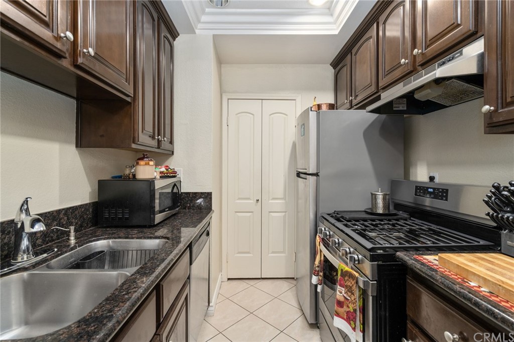 2925 East Spaulding Street, Unit 307 Long Beach, CA 90804 - Photo 10 of 18 a kitchen with stainless steel appliances granite countertop a sink stove and refrigerator