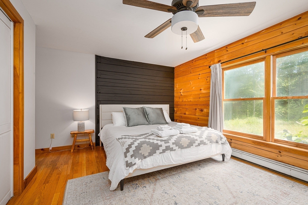 124 East Hawley Road Hawley, MA 01339 - Photo 9 of 39 a bedroom with a bed and a large window with wooden floor