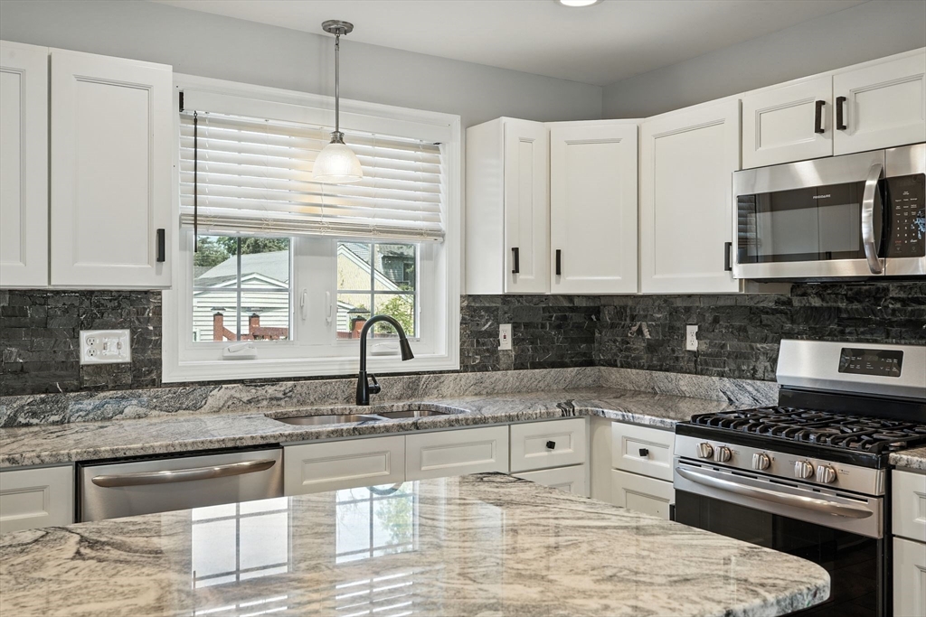24 Porter Street Springfield, MA 01104 - Photo 17 of 42 a kitchen with granite countertop a stove a sink and a microwave
