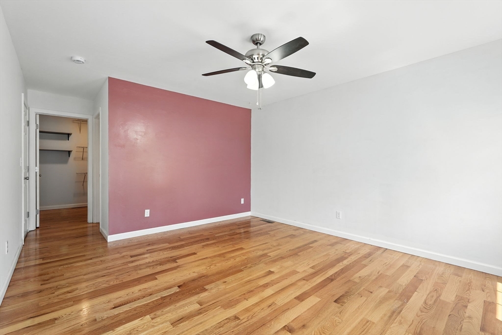 24 Porter Street Springfield, MA 01104 - Photo 23 of 42 a view of an empty room with wooden floor and a ceiling fan
