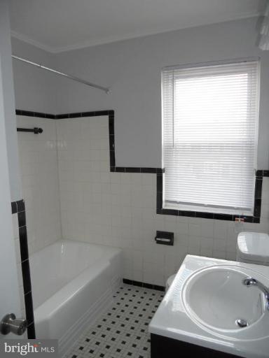 844 Bradhurst Road Baltimore, MD 21212 - Photo 12 of 17 a bathroom with a sink a window and a shower