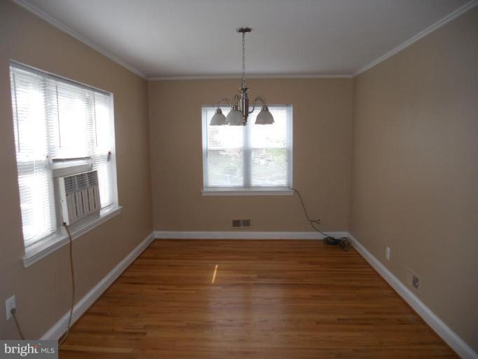 844 Bradhurst Road Baltimore, MD 21212 - Photo 4 of 17 an empty room with wooden floor and windows