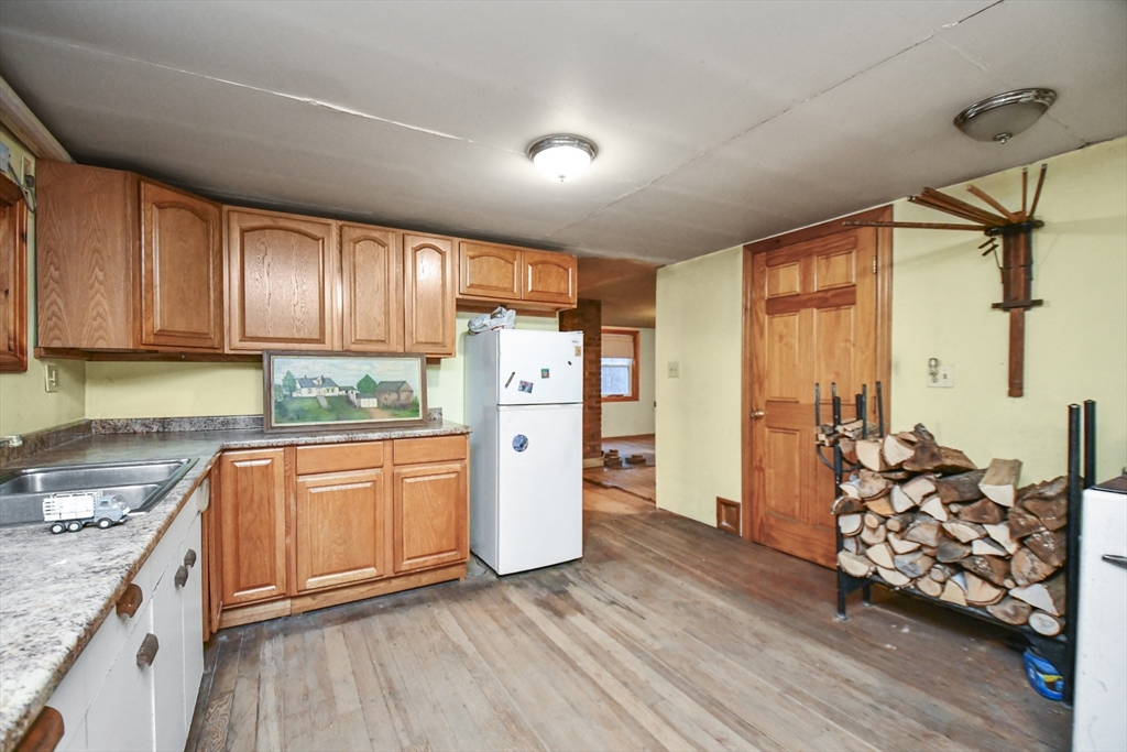 56 Pine Hill Road Orange, MA 01364 - Photo 15 of 30 a kitchen with stainless steel appliances granite countertop a refrigerator a stove a sink and dishwasher with wooden floor