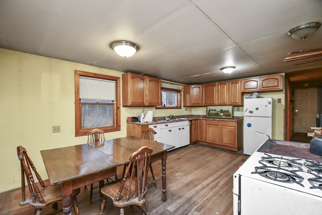 56 Pine Hill Road Orange, MA 01364 - Photo 19 of 30 a kitchen with a table chairs a sink dishwasher stove and cabinets with wooden floor