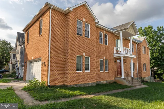 a front view of a house with a yard and trees