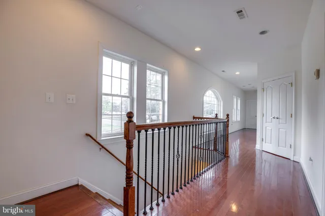 a view of a hallway with wooden floor and a window