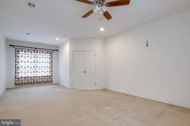 en empty room with windows and a ceiling fan