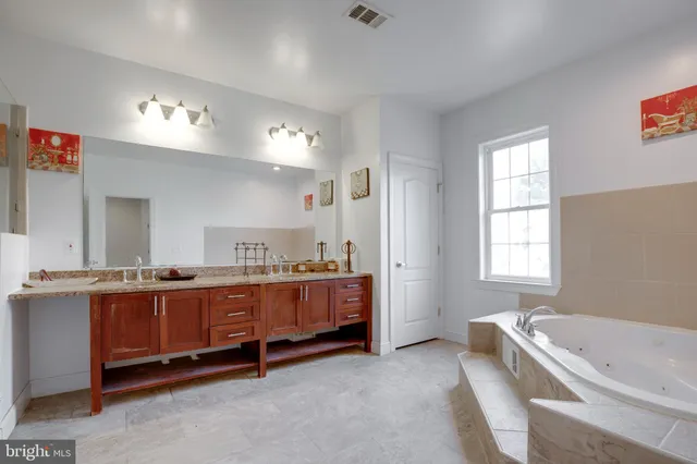 a bathroom with double vanity and a mirror