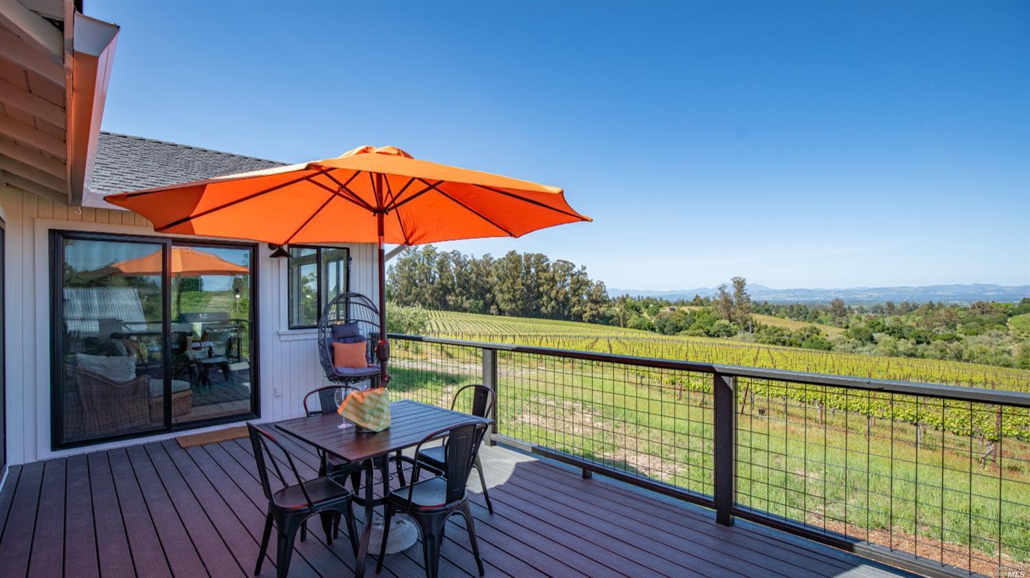 a view of a balcony with chairs and wooden floor