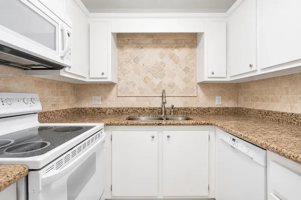 a kitchen with granite countertop a sink and a stove