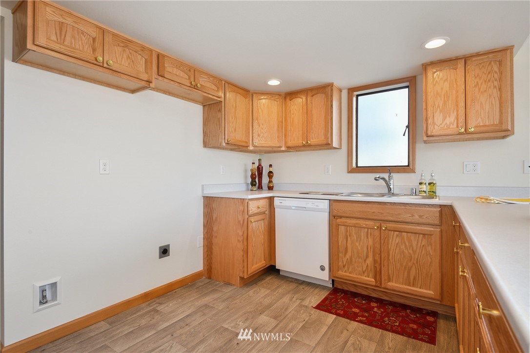 655 Main Street, Unit 204 Edmonds, WA 98020 - Photo 14 of 21 a kitchen with granite countertop a sink cabinets stainless steel appliances and a window