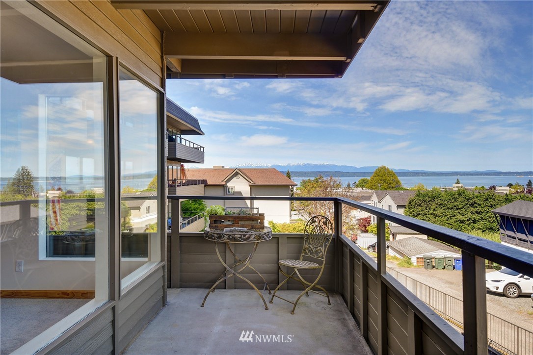 655 Main Street, Unit 204 Edmonds, WA 98020 - Photo 4 of 21 a view of a balcony with chairs and wooden floor
