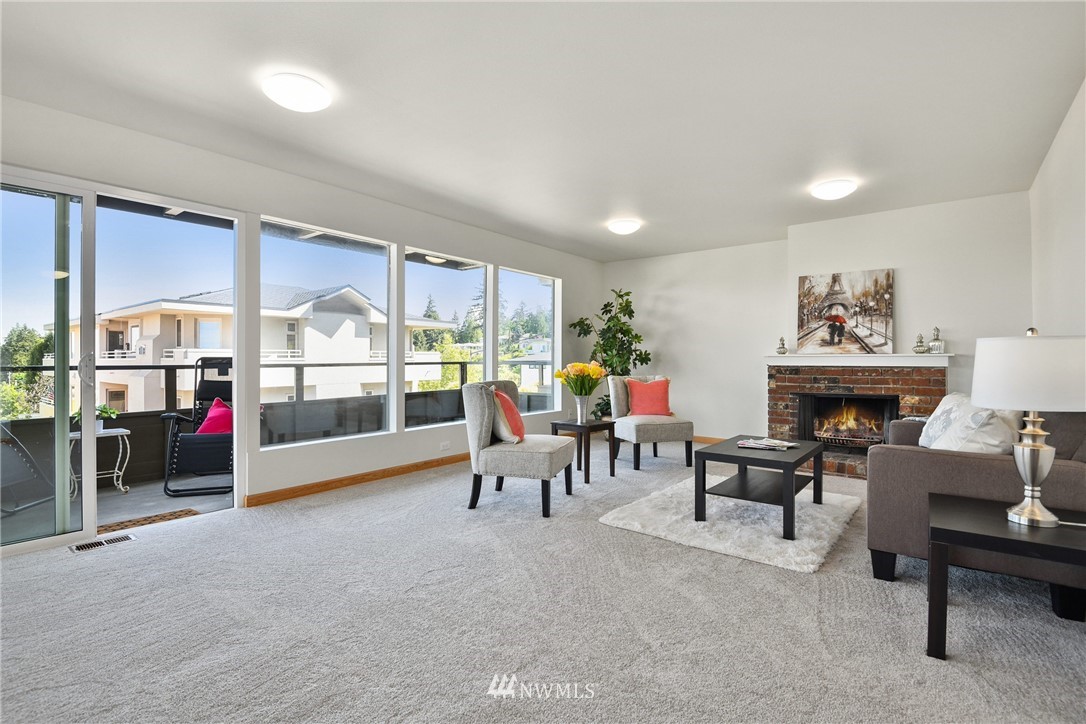 655 Main Street, Unit 204 Edmonds, WA 98020 - Photo 8 of 21 a living room with furniture a fireplace and a large window