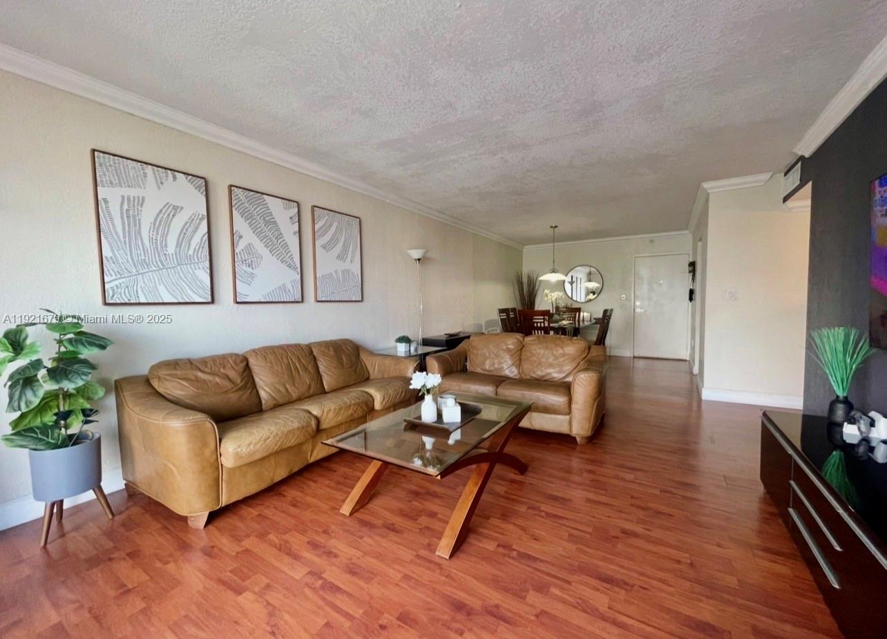 2851 Northeast 183rd Street, Unit 907E Aventura, FL 33160 - Photo 20 of 32 a living room with furniture potted plant and kitchen view