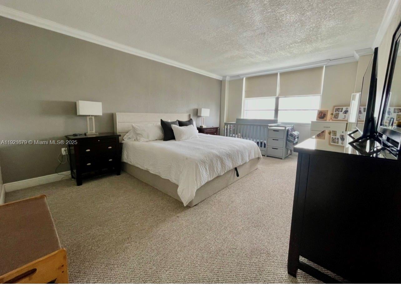 2851 Northeast 183rd Street, Unit 907E Aventura, FL 33160 - Photo 5 of 32 a bedroom with a bed and a flat tv screen on dresser