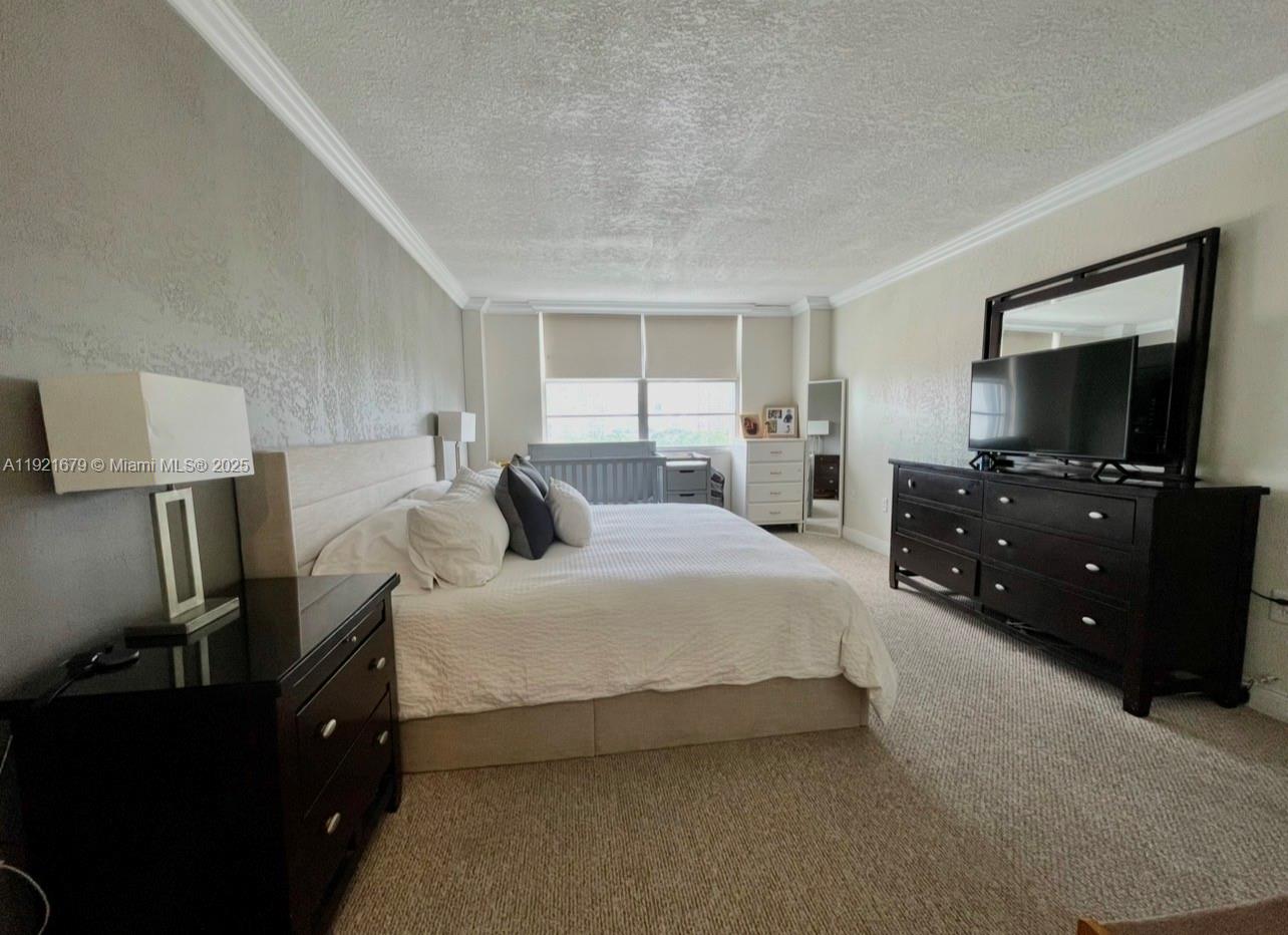 2851 Northeast 183rd Street, Unit 907E Aventura, FL 33160 - Photo 8 of 32 a bedroom with a bed and a flat tv screen on a dresser