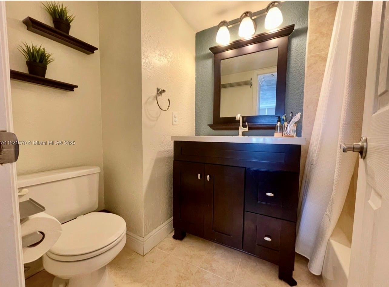 2851 Northeast 183rd Street, Unit 907E Aventura, FL 33160 - Photo 10 of 32 a bathroom with a toilet a sink and mirror