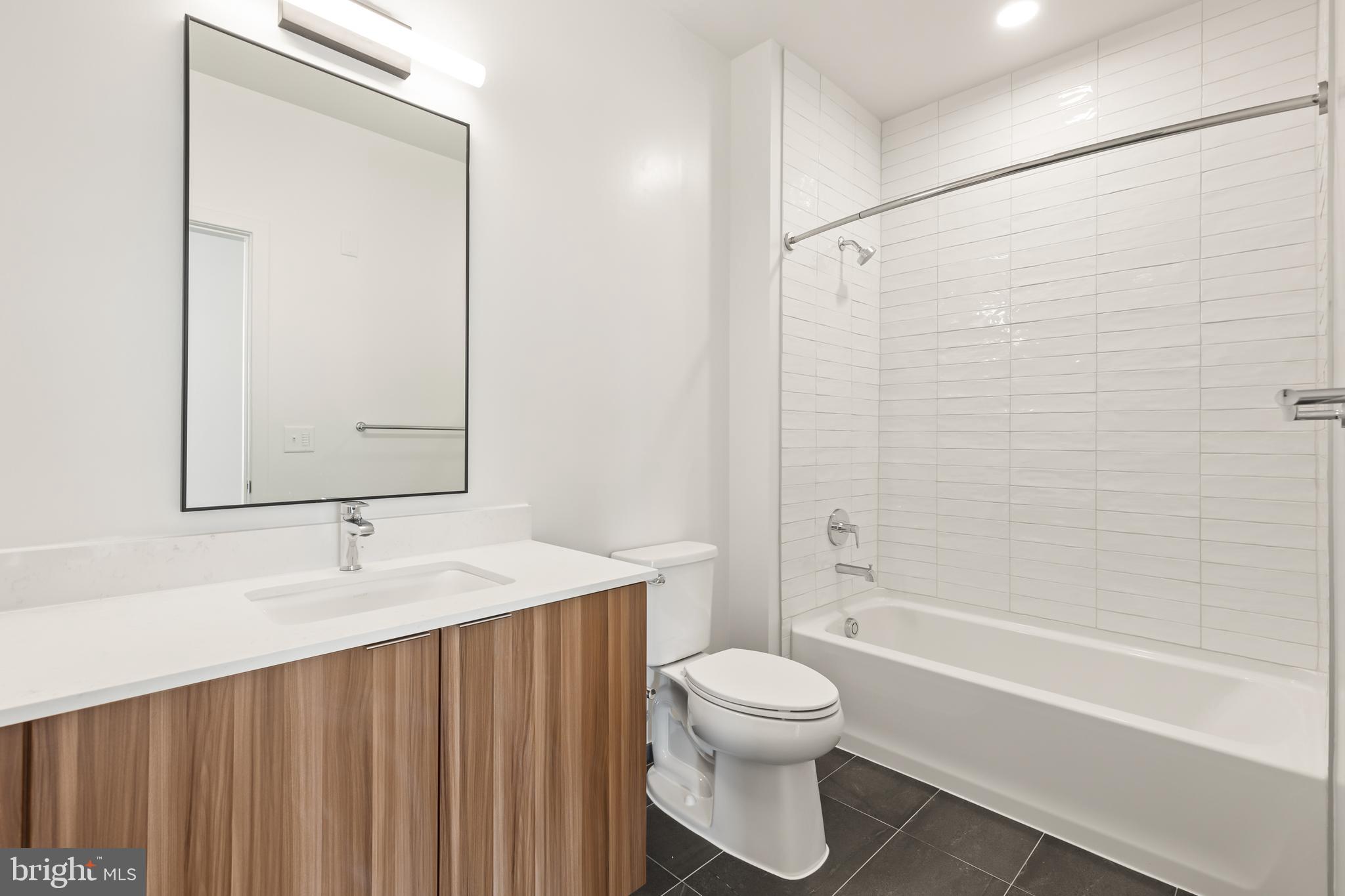 7175 12th Street Northwest, Unit 418 Washington, DC 20012 - Photo 5 of 31 a bathroom with a sink a toilet and shower