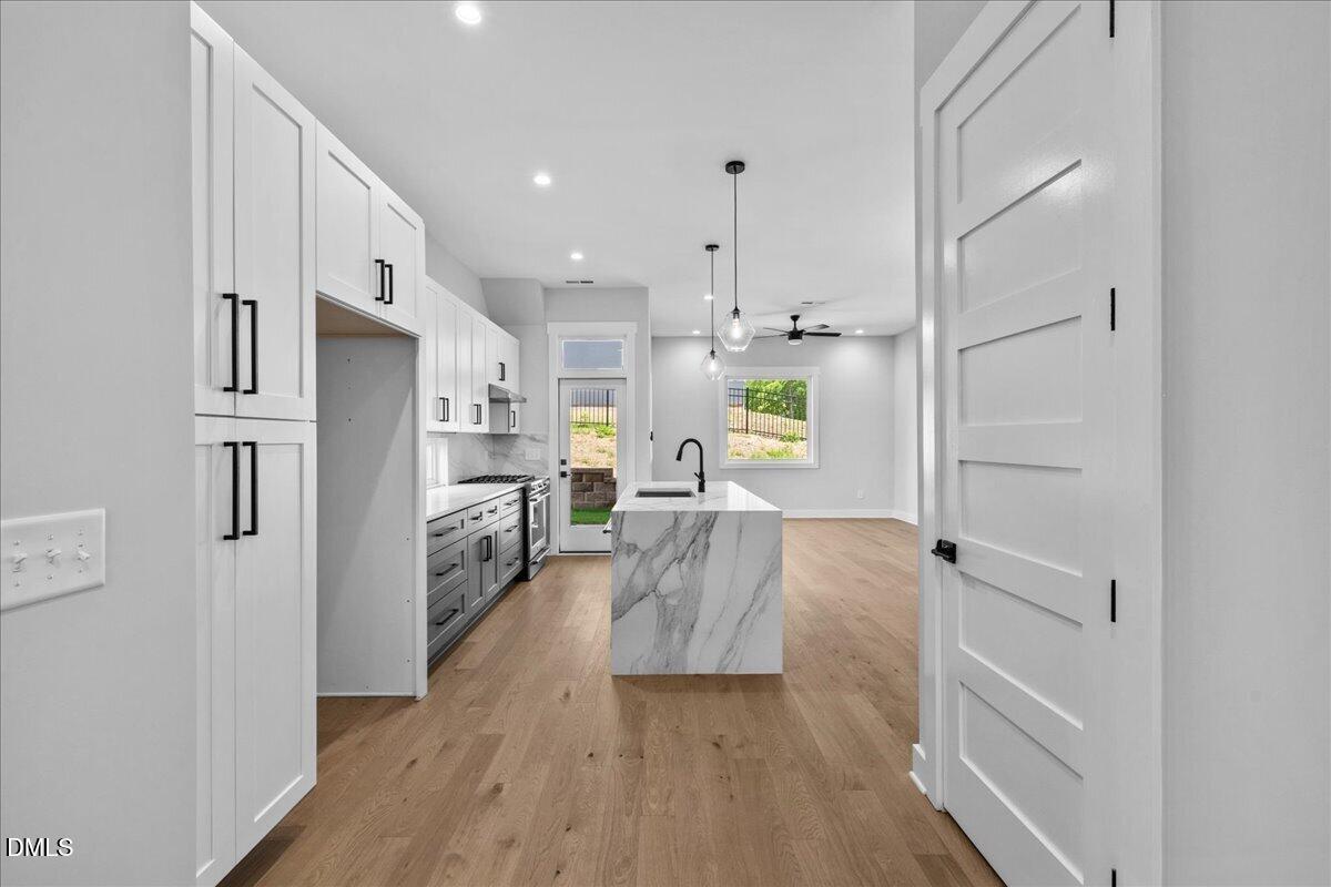 541 Bragg Street Raleigh, NC 27601 - Photo 11 of 44 a large white kitchen with white cabinets and stainless steel appliances