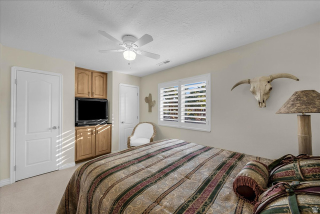 150 South Crystal Street, Unit 31 St. George, UT 84770 - Photo 17 of 20 Bedroom featuring ceiling fan, a textured ceiling, and light carpet