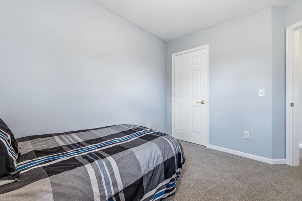 a bedroom with a bed and a painting on the wall