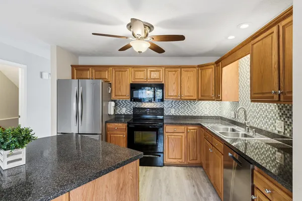 a kitchen with stainless steel appliances granite countertop sink stove top oven and refrigerator